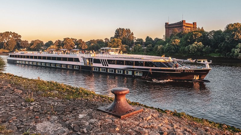 Flusskreuzfahrtschiff auf dem Fluss und Burg im Hintergrund