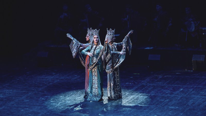 Asiatische Tänzerinnen in Kostümen auf Bühne
