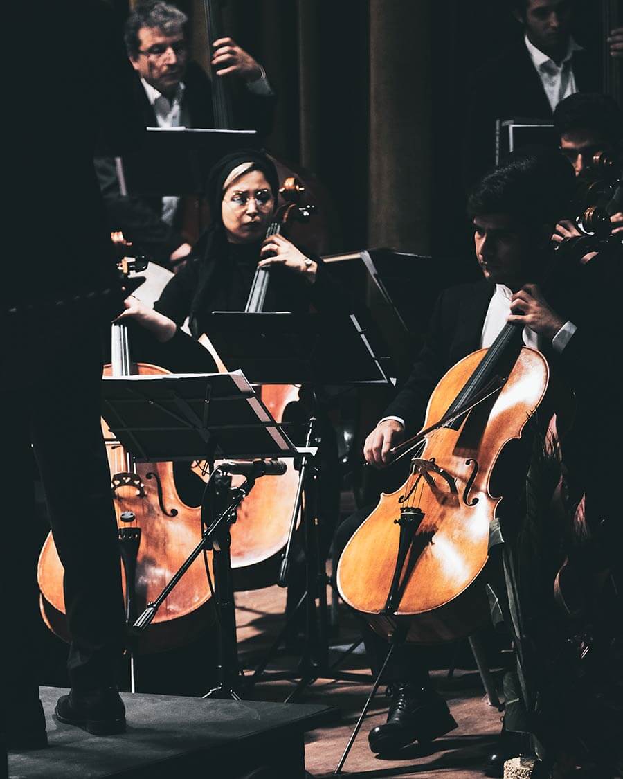 Sitzende Musiker mit Cellos