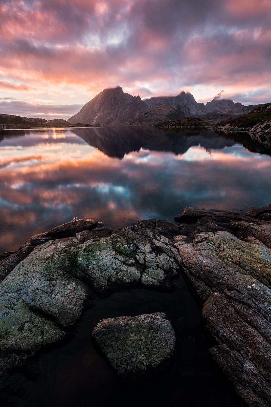 Roter Sonnenuntergang mit Blick auf Wasser und Steine