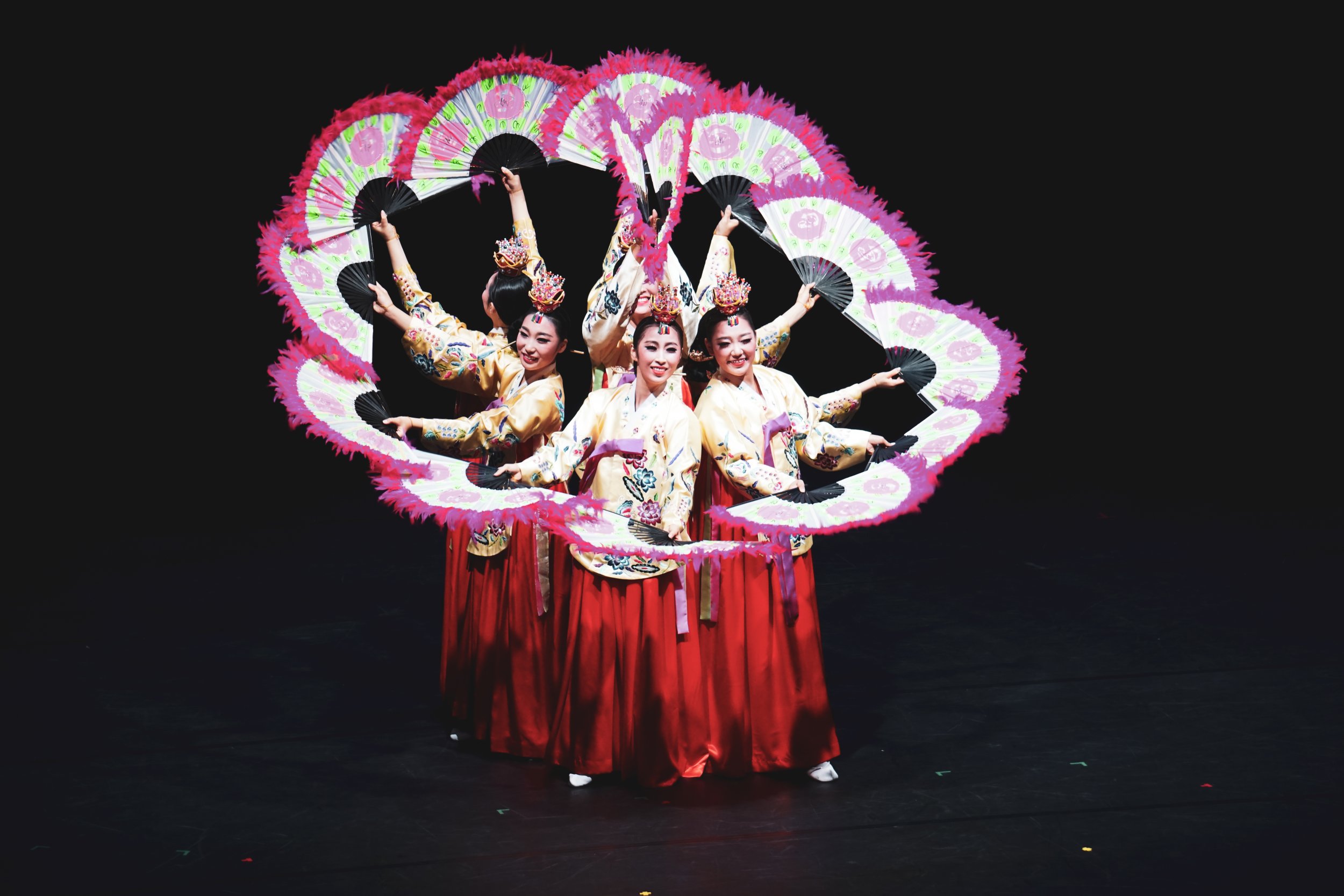Traditionell angezogenen Tänzerinnen auf einer Bühne mit Fächern in der Hand