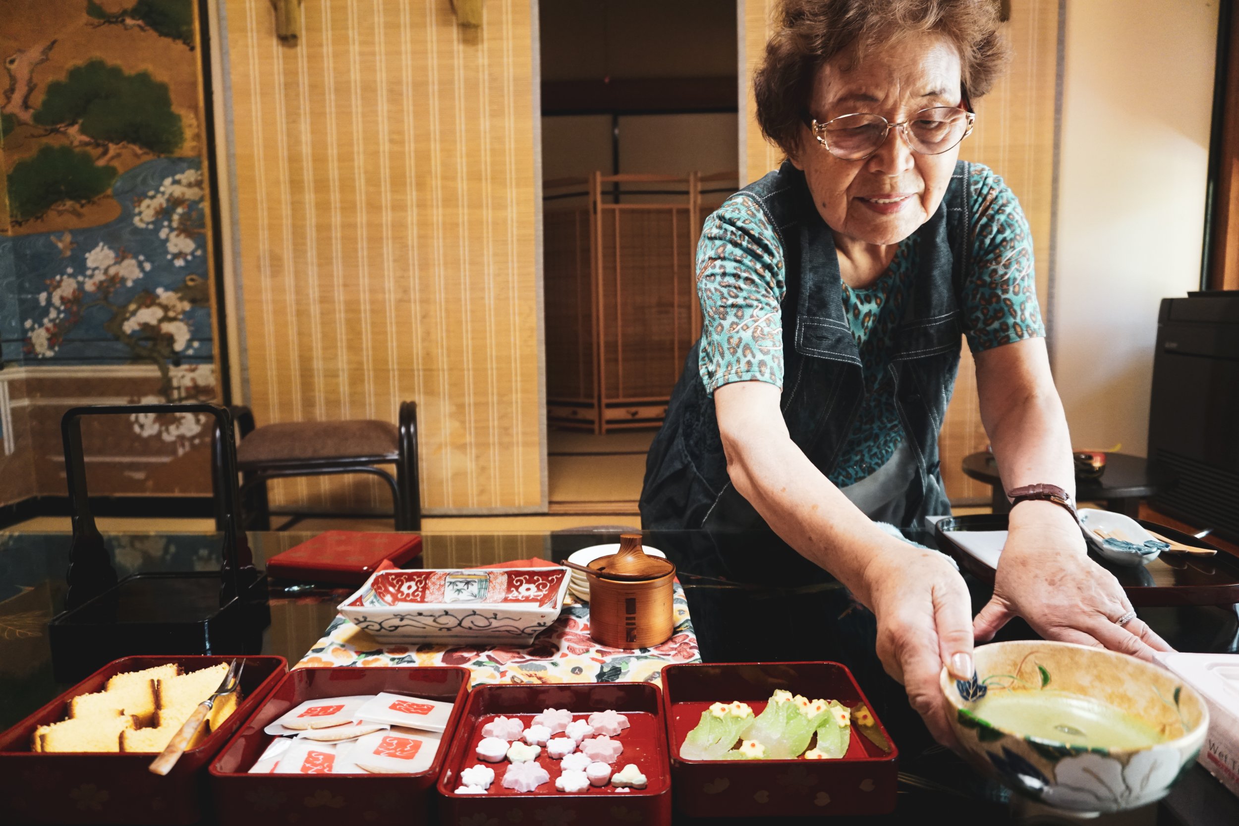 Ältere Frau serviert Tee auf japanische Art