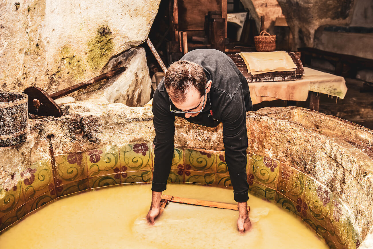 Man scooping paper out of a water basin