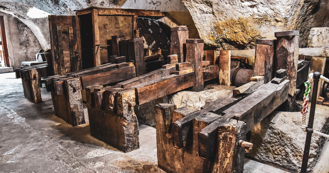 Old machine made of wooden hammers in stone walls