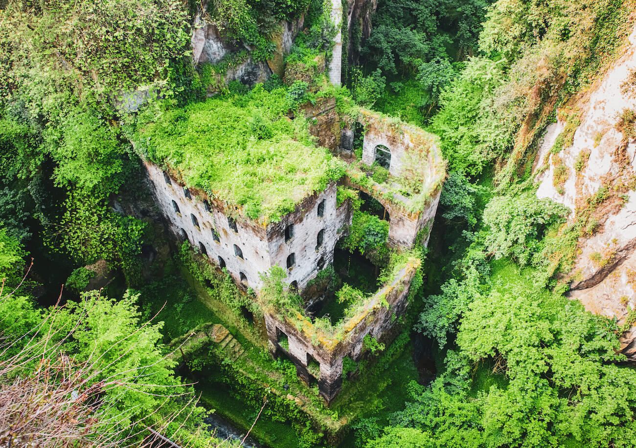 Old ruins of a mill in a green gorge